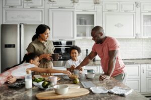 A family fixes a meal together in the kitchen as an example of everyday discipleship.